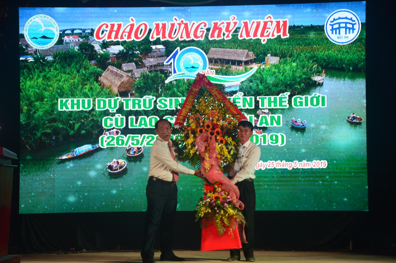 Chủ tịch UBND tỉnh Đinh Văn Thu thừa ủy quyền của Thủ tướng Chính phủ tặng lẵng hoa cho Ban Quản lý Khu dự trữ sinh quyển thế giới Cù Lao Chàm - Hội An. Ảnh: L.T